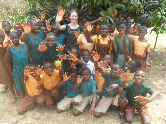 A student with a group of students waving at the camera